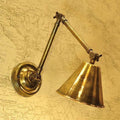 Henley Triple Adjustable Wall Light in antique brass finish mounted on wall with adjustable arm and conical shade