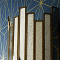 Pooky Melville Vintage Glass Wall Light with antique brass frame and vintage glass panels against blue geometric wall
