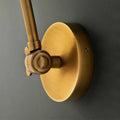 Close-up of Pooky Stork Wall Light adjustable brass wall mount in antique finish