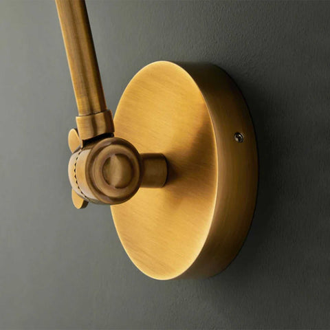 Close-up of Pooky Stork Wall Light adjustable brass wall mount in antique finish