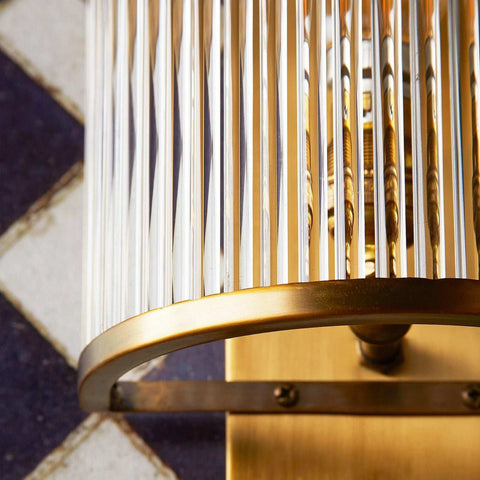 Close-up of Pooky Roddy Wall Light with clear glass rods and brass semi-circular frame showcasing Art Deco design.