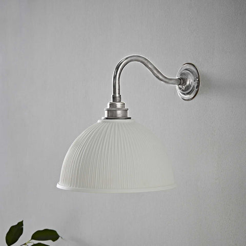 Denton Ribbed Ceramic medium wall light with handmade ribbed ceramic shade and brushed metal arm mounted on grey wall