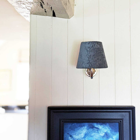 Finberry Blue Velvet fabric shade wall light with swan neck design and polished brass finish mounted on white wall above framed artwork