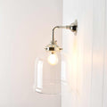 Hythe small clear glass shade wall light with polished metal fixture illuminating interior space