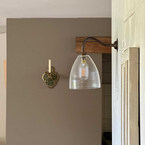 Margate small ribbed glass shade wall light with hand-blown textured glass and metal arm mounted on a beige wall.