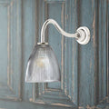 Pooky Tiny Qilin bathroom wall light with swan neck and prismatic glass shade on rustic blue wooden wall