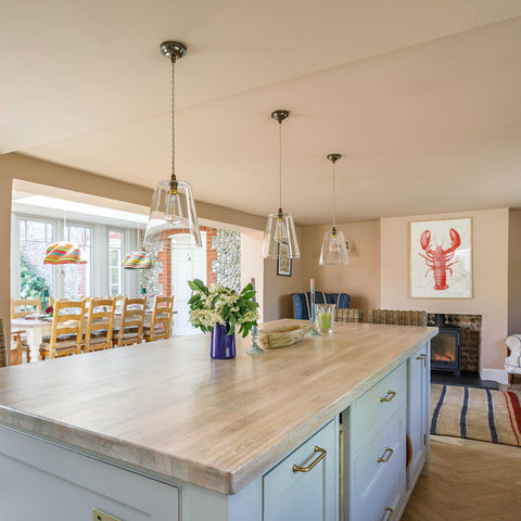 Newbury large clear glass shade pendant lights hanging over a kitchen island with modern interior decor.