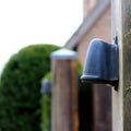 Bourne Outdoor Mast Light in black finish mounted on wooden pole for outdoor pathway lighting