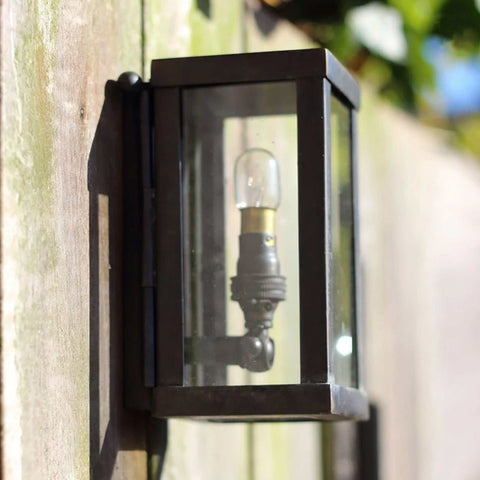 Chiswick Outdoor Wall Light small black cast brass wall-mounted lantern with clear glass panels on wooden outdoor wall