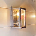 Chiswick Outdoor Wall Light small polished brass with glass panels mounted on exterior wall emitting warm light