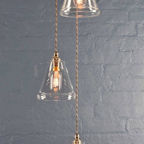 Rye small clear glass shade cluster pendant light with hand-blown glass and adjustable twisted cords against a gray brick wall